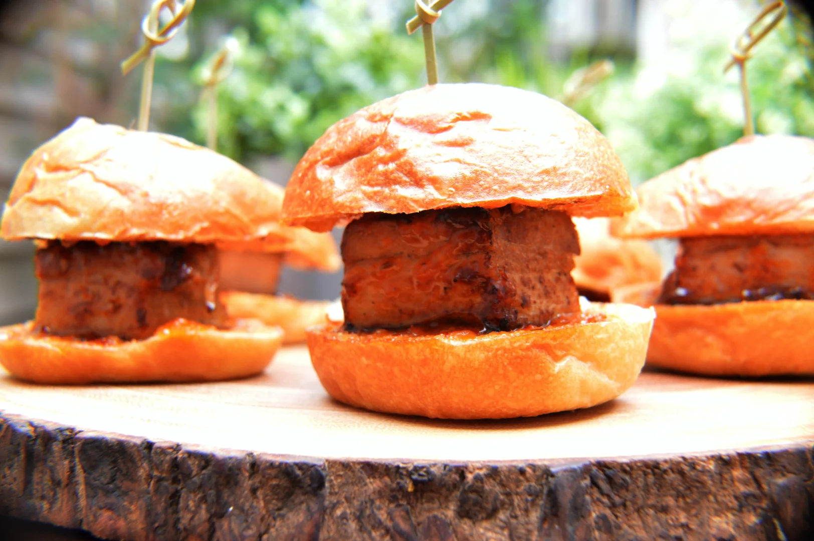 XIM pork belly sliders on a wooden display