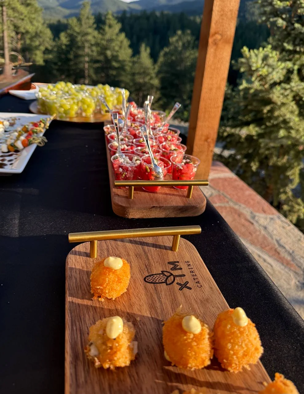 Appetizers on XIM serving boards overlooking the mountains
