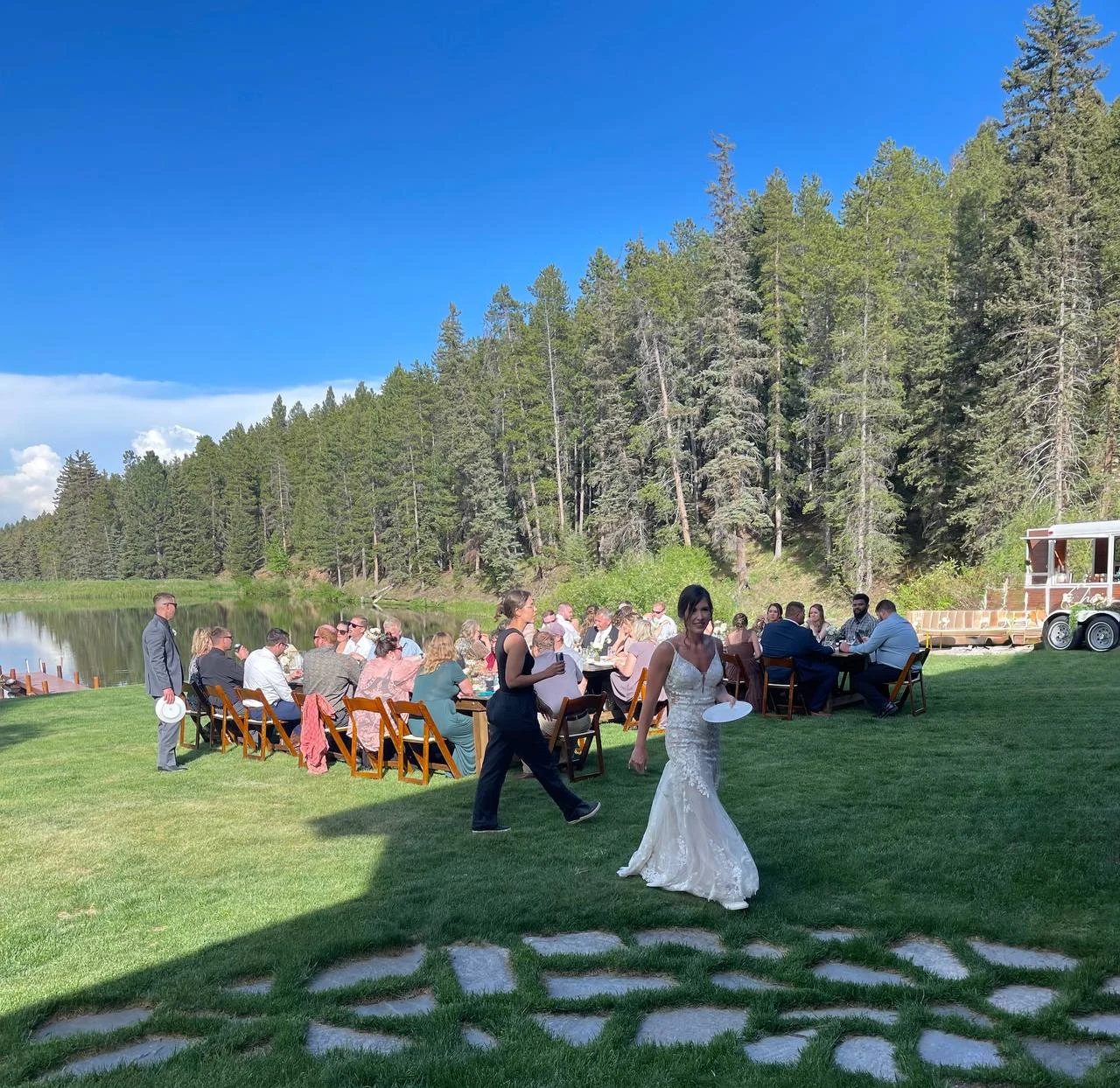 Bride and guests enjoying an outdoor lakeside wedding reception