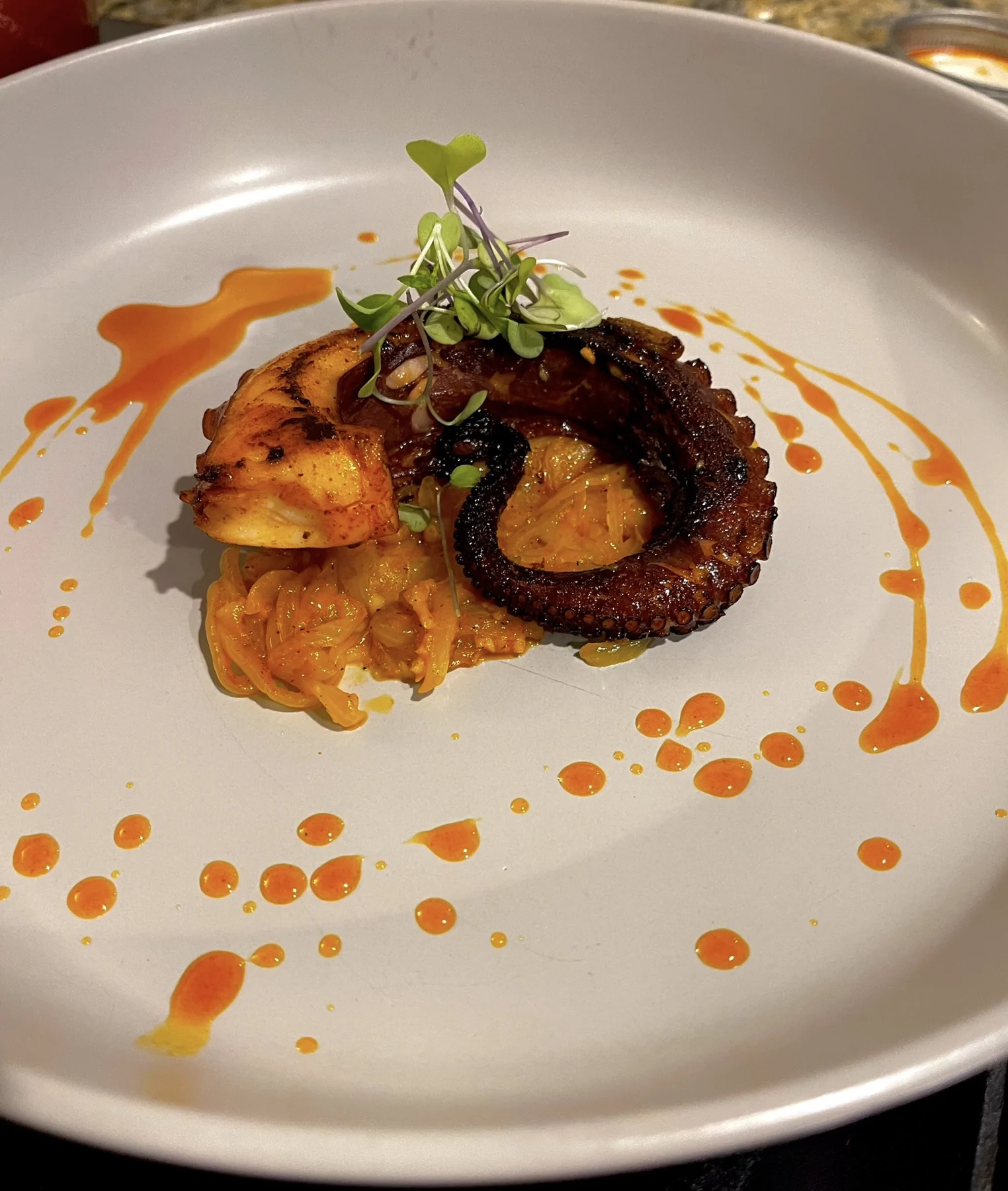 A plated seafood dish with colorful accompaniments
