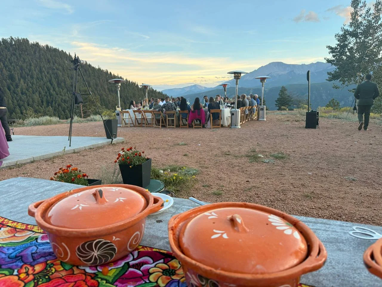 Terracotta serving pots overlooking an outdoor mountain dinner